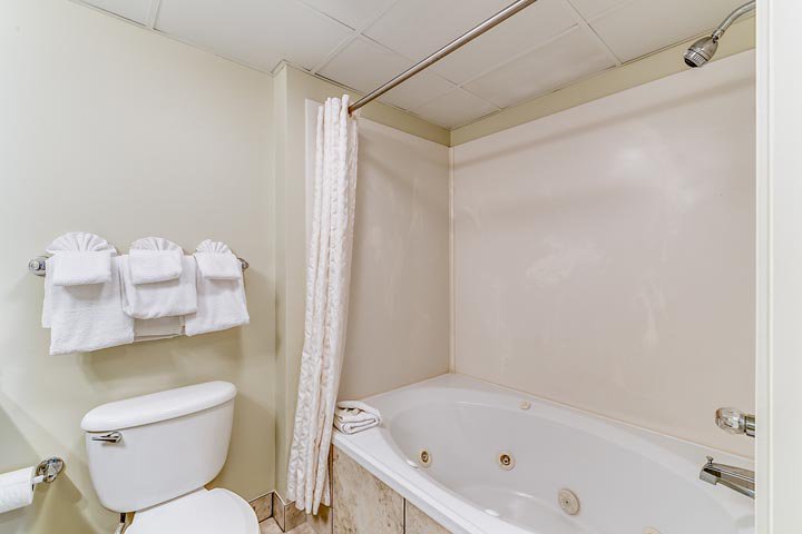 a standard bathroom with a toilet, bathtub, and towels