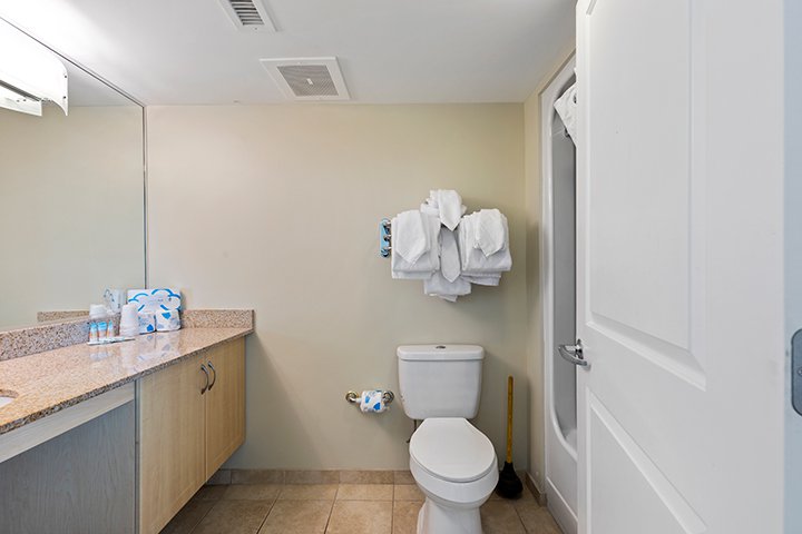 A bathroom with a toilet, sink, and mirror