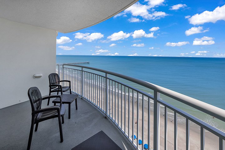 A balcony with a view of the ocean and beach