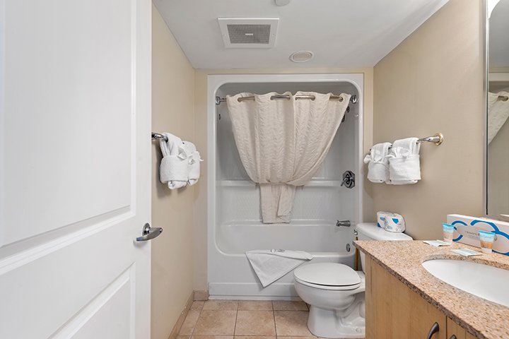 A clean bathroom with a toilet, shower, and sink