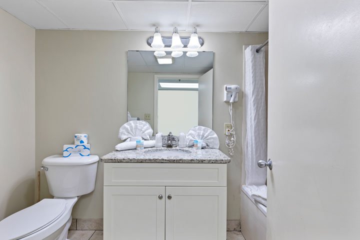 A bathroom with a toilet, sink, and shower.