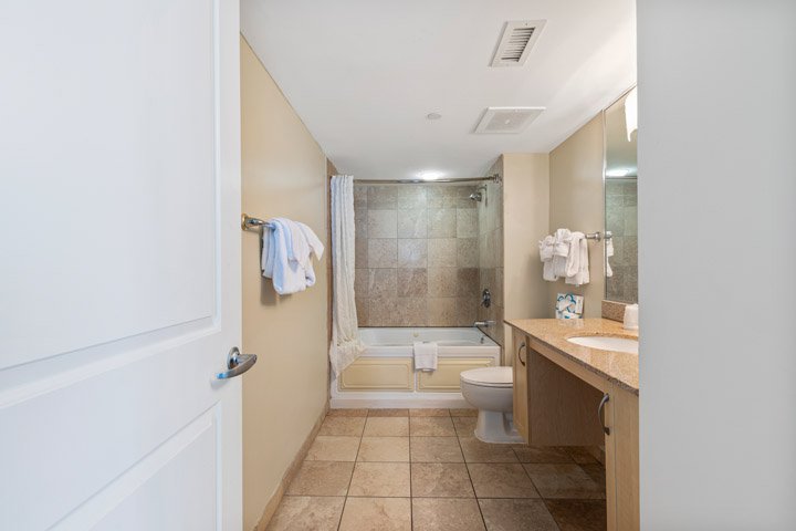 A clean bathroom with a toilet, shower, bathtub, sink, and mirror.
