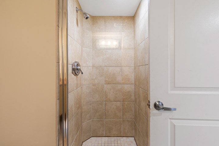 a shower with a tiled floor and walls
