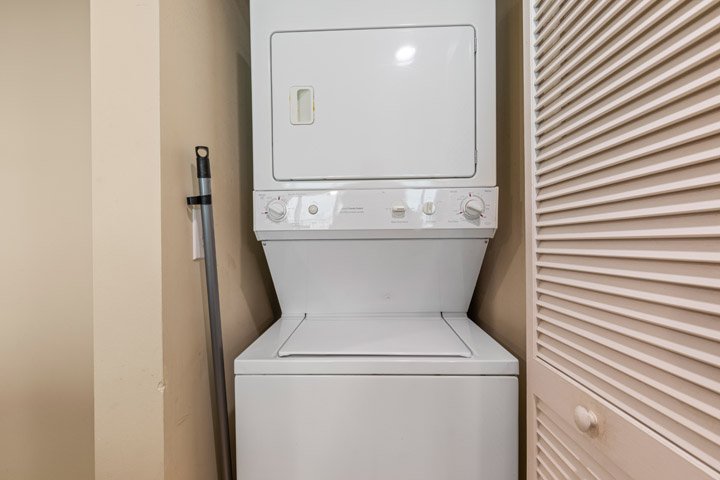 A stacked washer and dryer in a small closet.