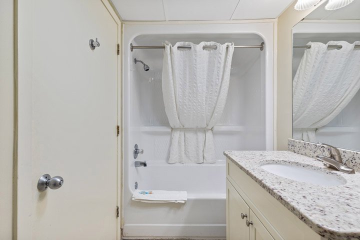 a bathroom with a sink, mirror, and bathtub