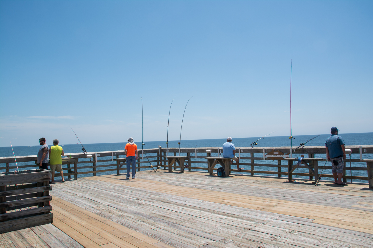 picture of a fishing pier with a lot of fishermen on it. 